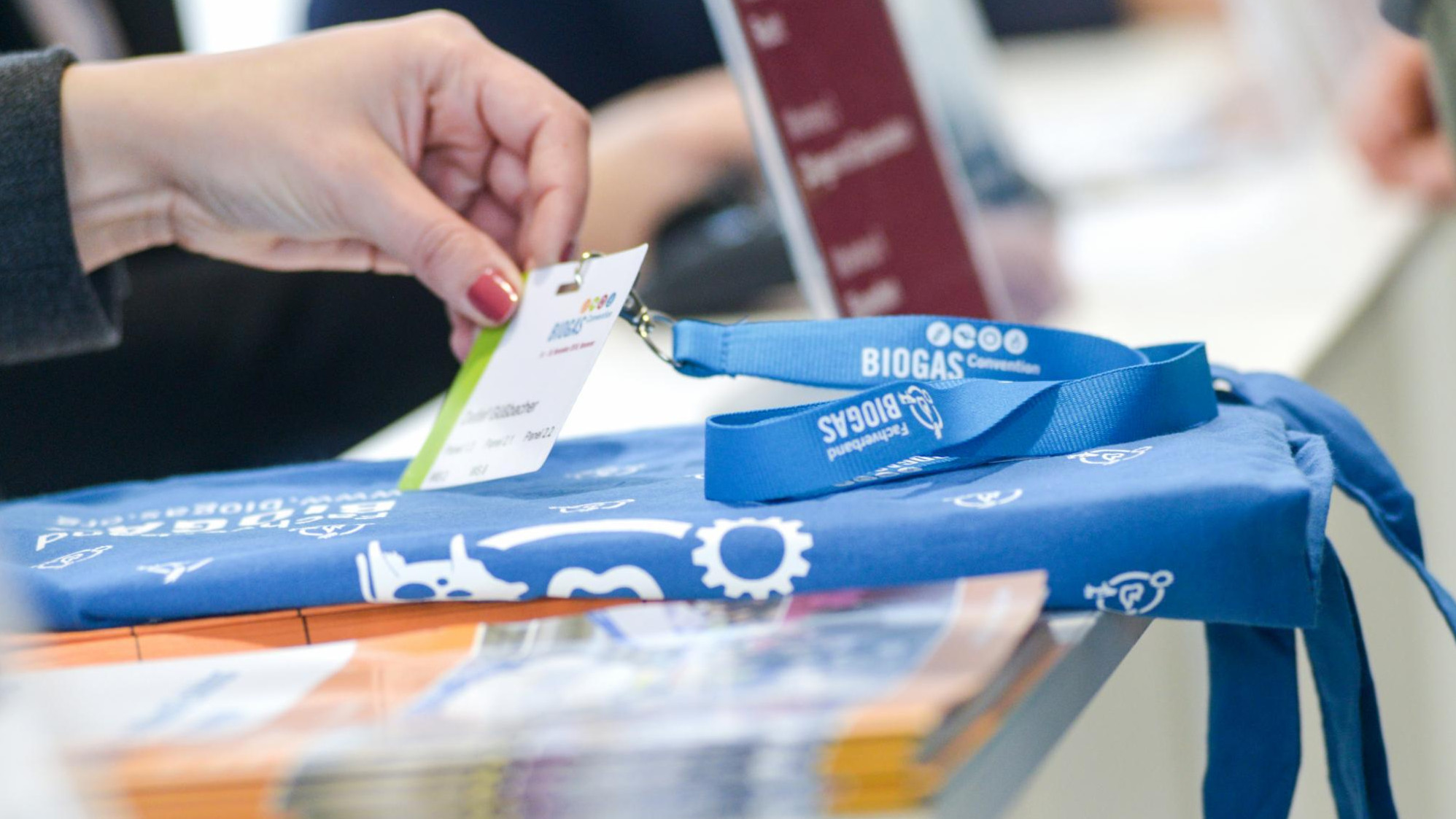 Person teilt Namensschild und Give-Aways aus